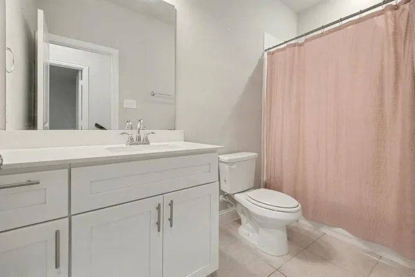 a bathroom with a sink a toilet a mirror and shower curtain