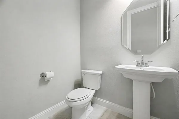 a bathroom with a sink a toilet and mirror