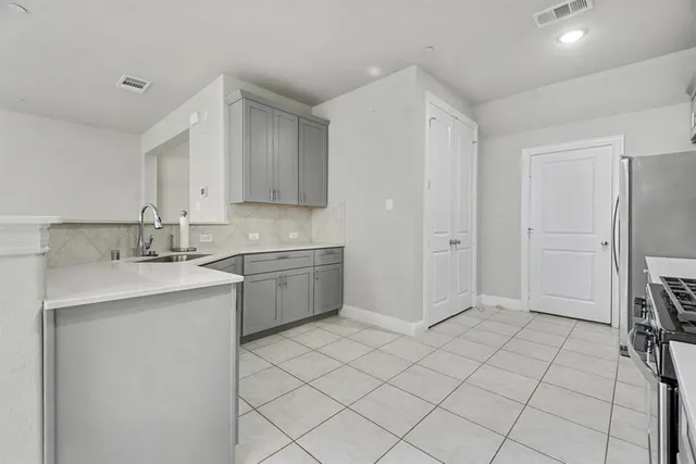 a kitchen with stainless steel appliances a sink and a refrigerator