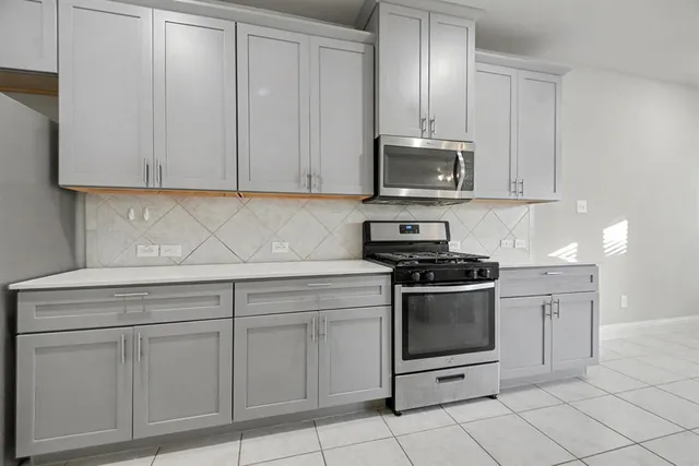 a kitchen with white cabinets and stainless steel appliances