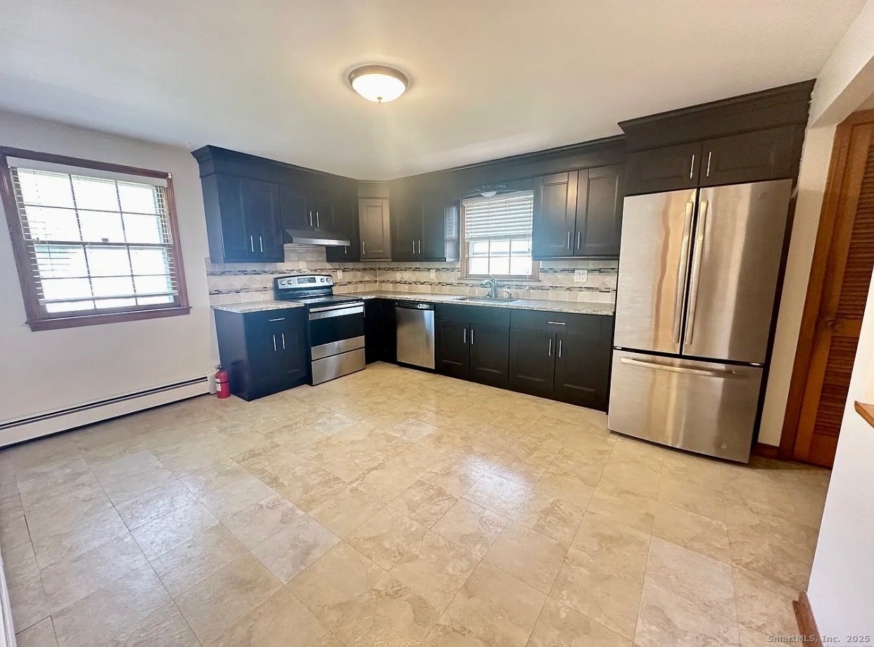 432 Wiklund Avenue Stratford, CT 06614 - Photo 12 of 19 a kitchen with granite countertop a refrigerator and a stove top oven