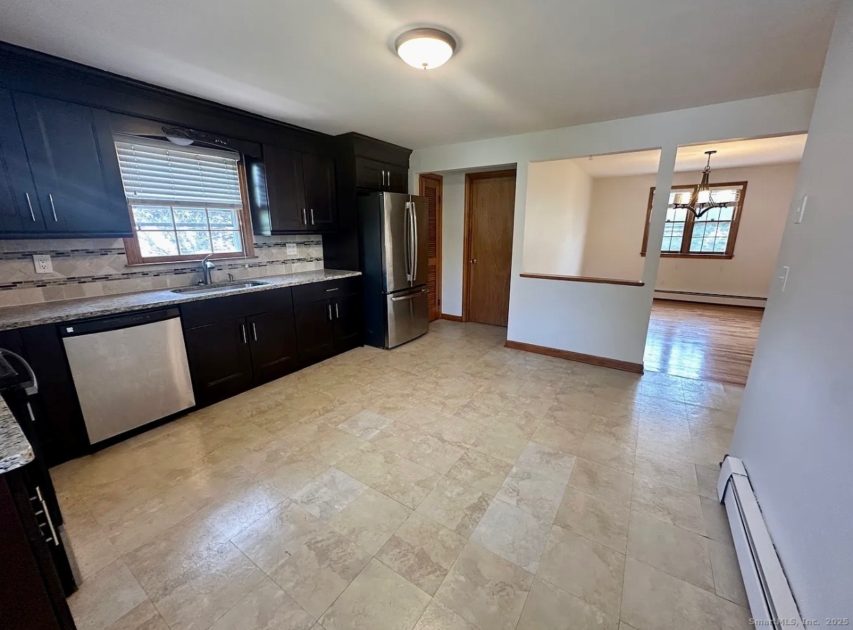 432 Wiklund Avenue Stratford, CT 06614 - Photo 13 of 19 a large kitchen with kitchen island granite countertop a sink a stove a refrigerator a counter top space and cabinets