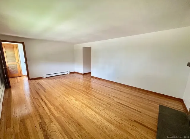 a view of empty room with wooden floor
