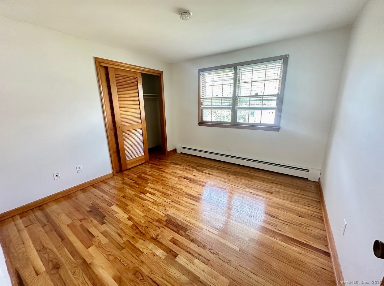 432 Wiklund Avenue Stratford, CT 06614 - Photo 18 of 19 a view of an empty room with wooden floor and a window