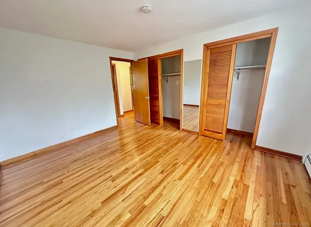 an empty room with wooden floor and closet