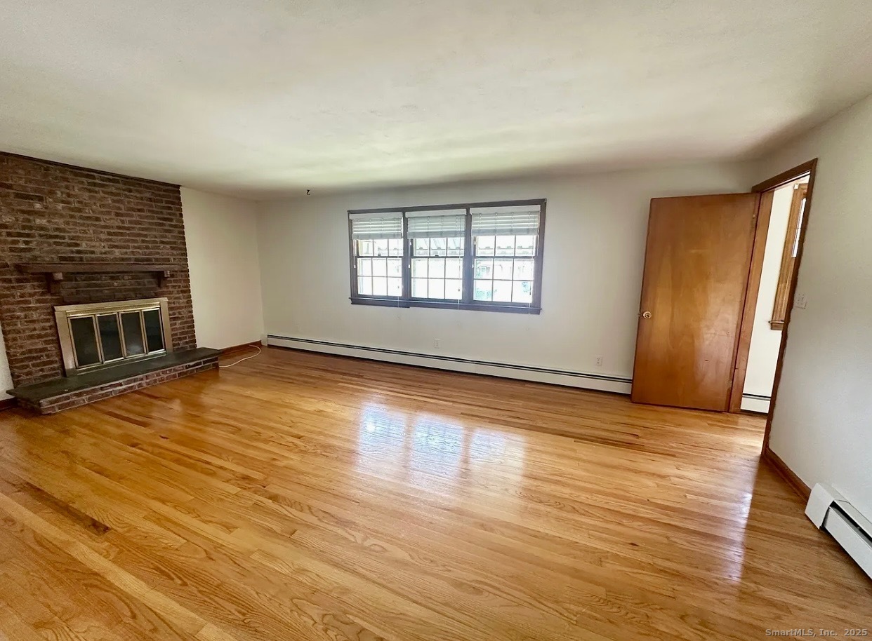 432 Wiklund Avenue Stratford, CT 06614 - Photo 6 of 19 an empty room with wooden floor and windows