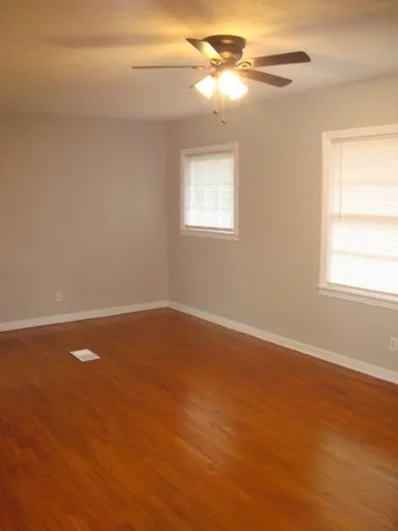 a view of a room with wooden floor and fan