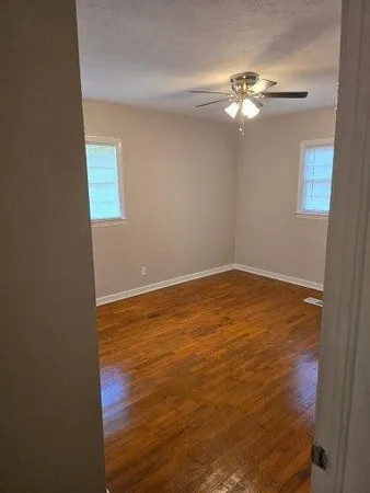 a view of a room with wooden floor and fan