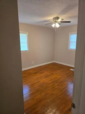 a view of a room with wooden floor and fan