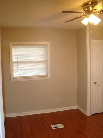 an empty room with a window and wooden floor