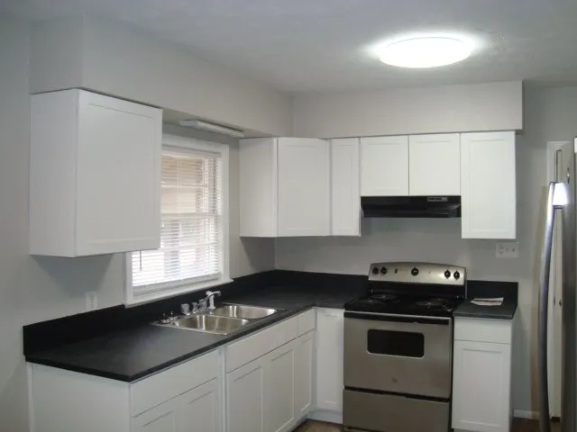 a kitchen with a sink stove and microwave