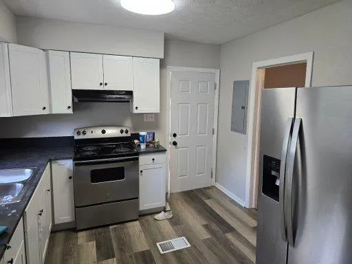 a kitchen with stainless steel appliances a stove a refrigerator and cabinets