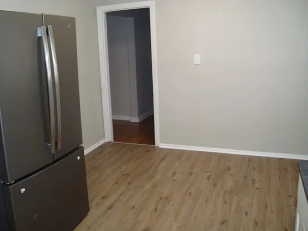 an empty room with wooden floor and a window