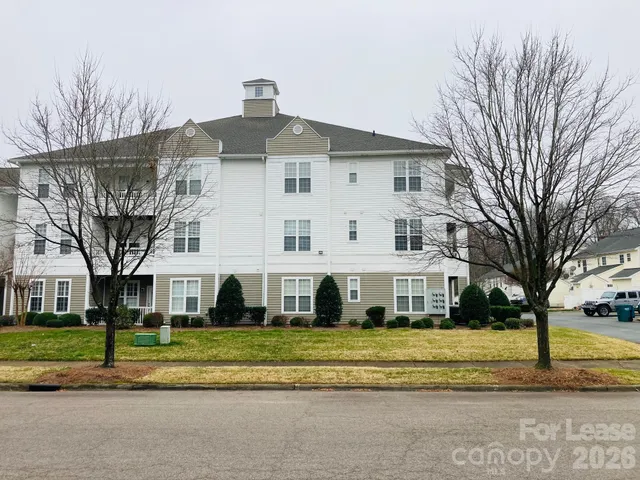 a view of a white house with a large trees