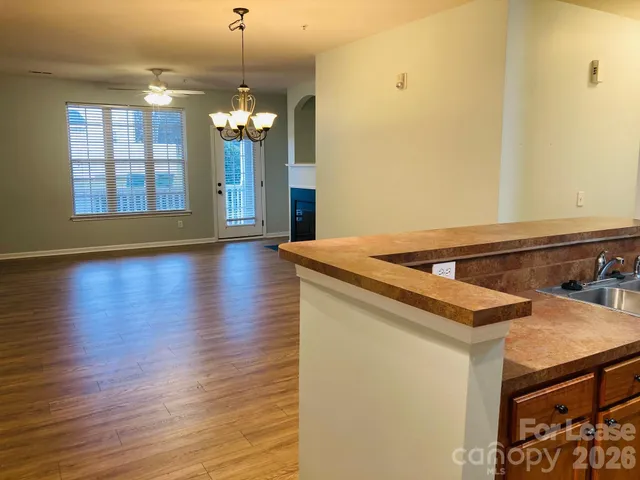 a view of a kitchen with a sink wooden floor and a chandelier