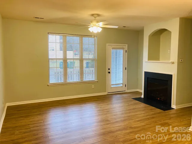 a view of an empty room with a fireplace and a window