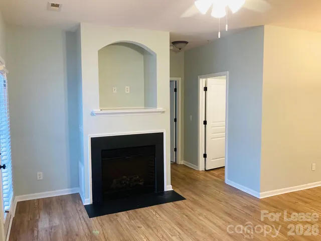 an empty room with wooden floor and fireplace