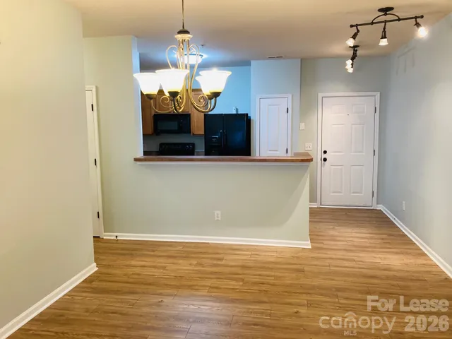 a view of a room with wooden floor and chandelier