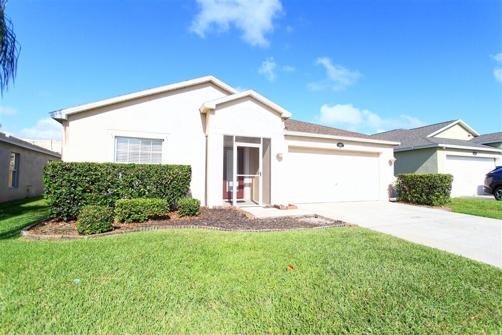 a view of a backyard with plants and large tree