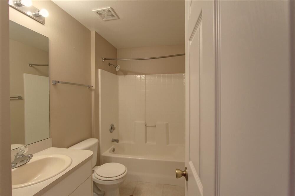 2477 Deercroft Drive Melbourne, FL 32940 - Photo 11 of 30 a bathroom with a granite countertop sink toilet and shower