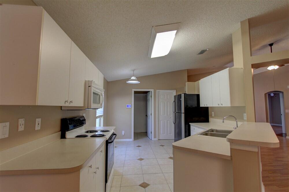 2477 Deercroft Drive Melbourne, FL 32940 - Photo 22 of 30 a kitchen that has a sink and a stove