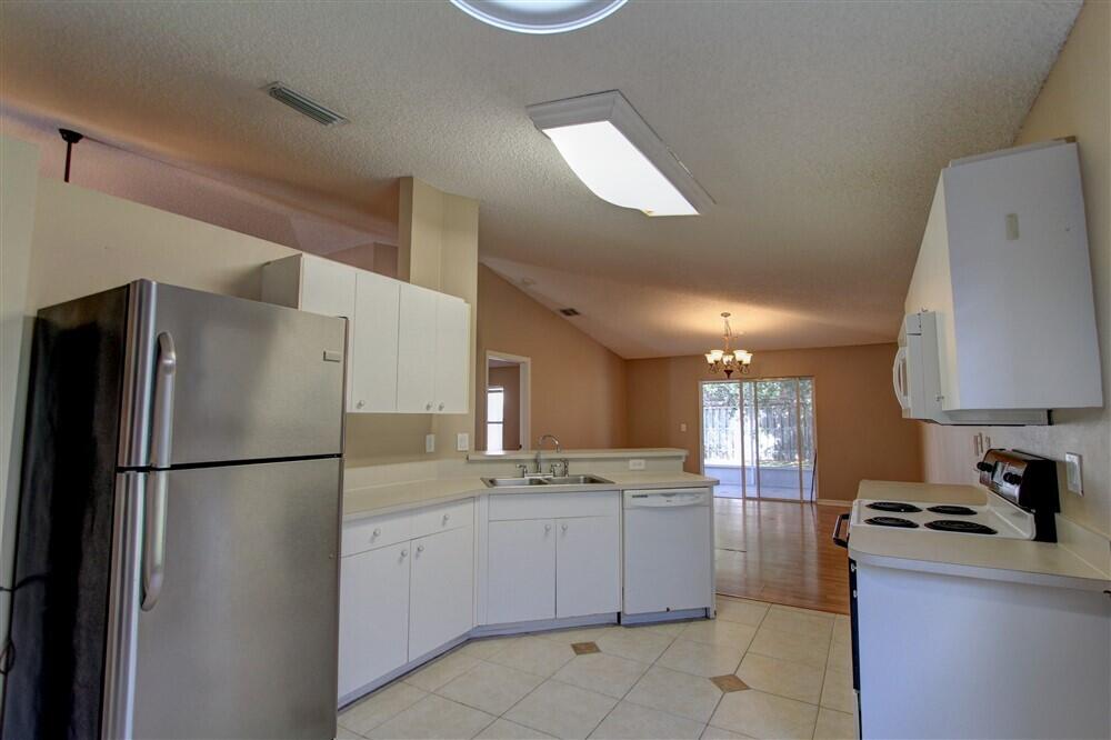 2477 Deercroft Drive Melbourne, FL 32940 - Photo 23 of 30 a kitchen with a refrigerator sink and cabinets