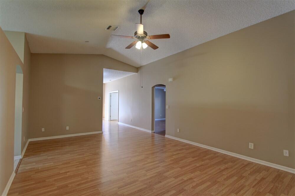 2477 Deercroft Drive Melbourne, FL 32940 - Photo 25 of 30 a view of an empty room with wooden floor and a ceiling fan