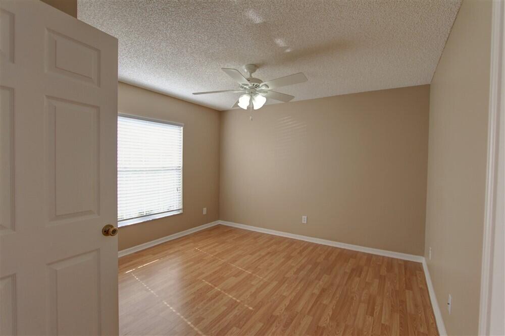 2477 Deercroft Drive Melbourne, FL 32940 - Photo 3 of 30 an empty room with a window and a fan