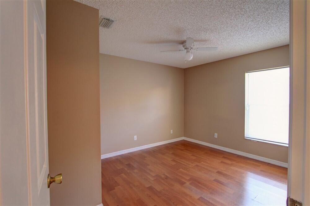 2477 Deercroft Drive Melbourne, FL 32940 - Photo 8 of 30 an empty room with a window and a ceiling fan