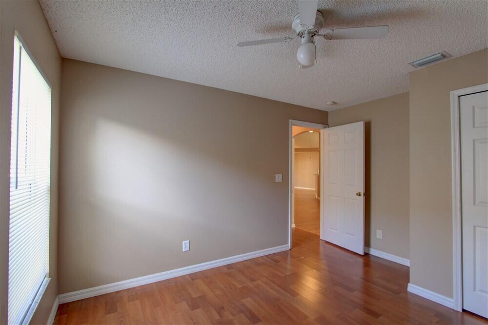 2477 Deercroft Drive Melbourne, FL 32940 - Photo 9 of 30 an empty room with wooden floor and fan