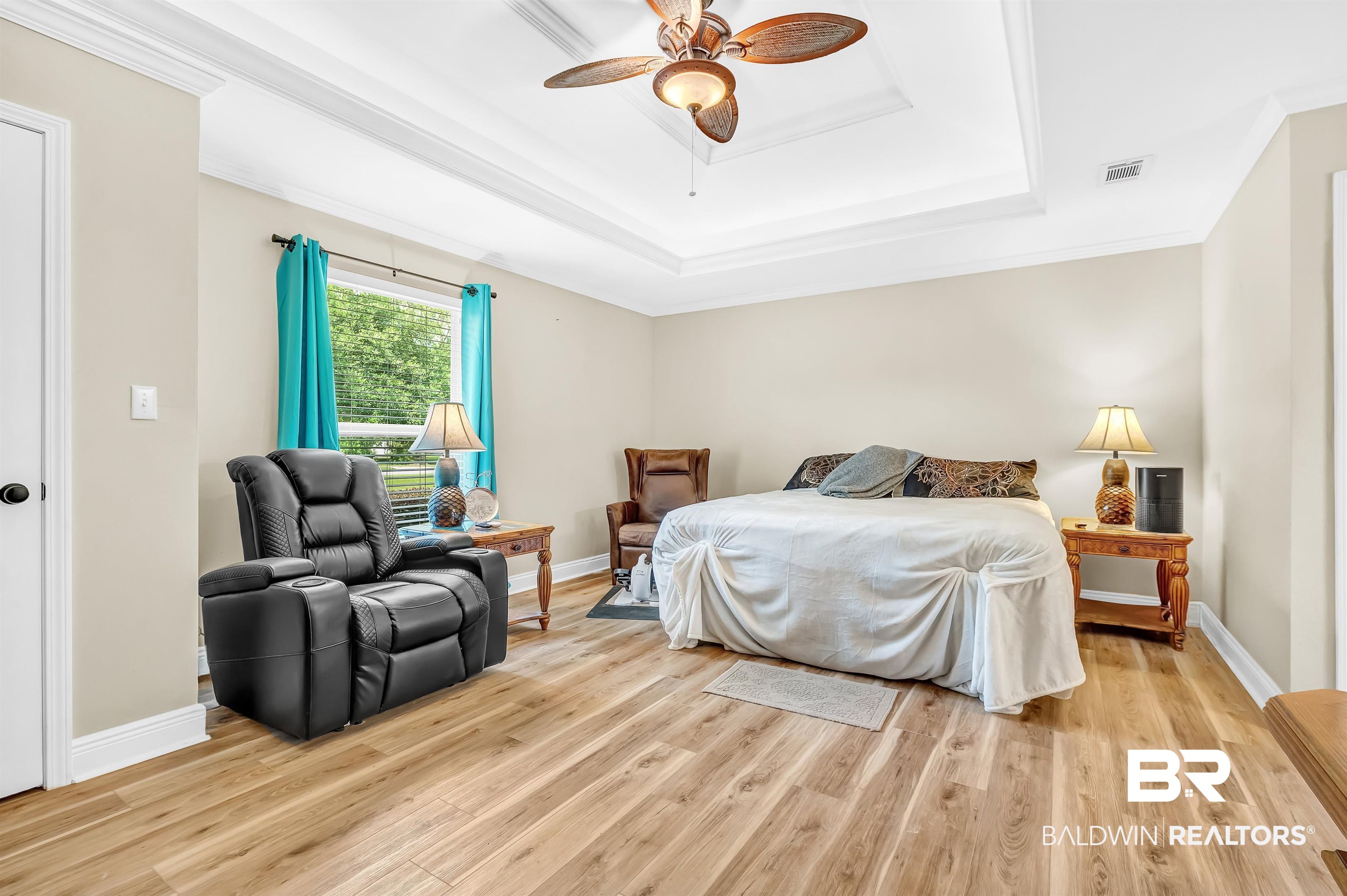 24551 Wolf Bay Drive Foley, AL 36535 - Photo 35 of 59 Bedroom featuring a tray ceiling, light wood finished floors, ornamental molding, and a ceiling fan