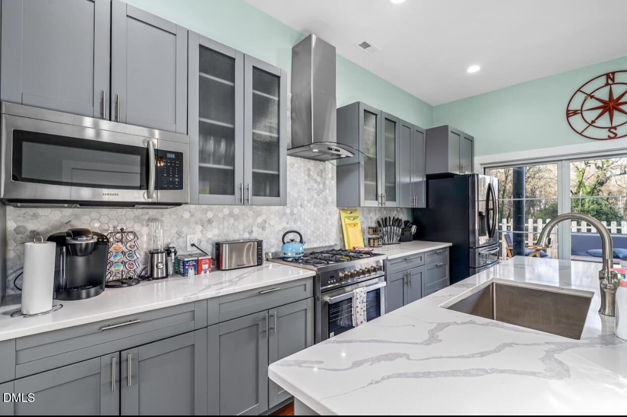 603 Lee Street Durham, NC 27701 - Photo 13 of 40 a kitchen with stainless steel appliances kitchen island granite countertop a sink dishwasher stove and microwave with wooden cabinets