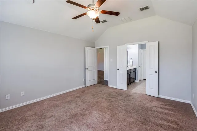 an empty room with closet and a ceiling fan