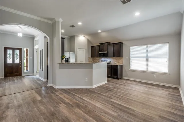 a view of a kitchen with microwave and refrigerator