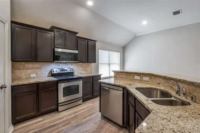 a kitchen with granite countertop a sink and a stove top oven