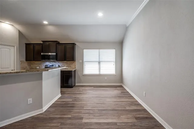 a kitchen with granite countertop a stove a sink and a microwave