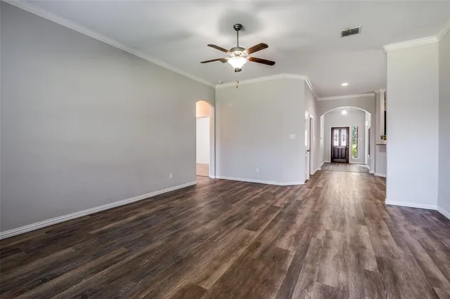 a view of a room with wooden floor and ceiling fan