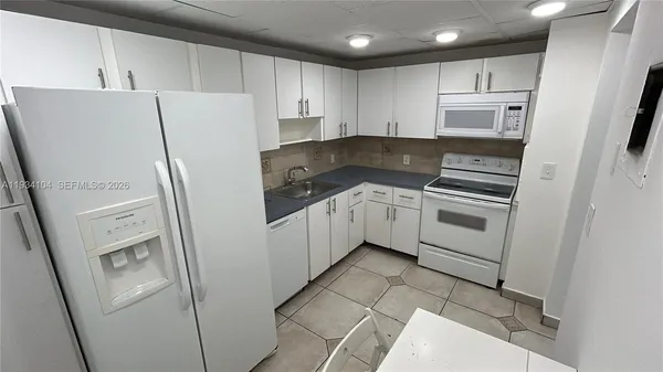 a kitchen with a refrigerator sink stove and cabinets