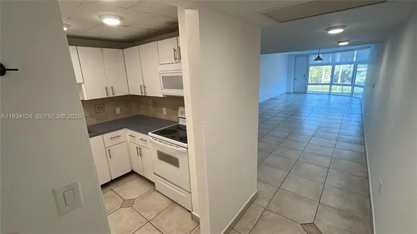 a kitchen with granite countertop white cabinets and white appliances