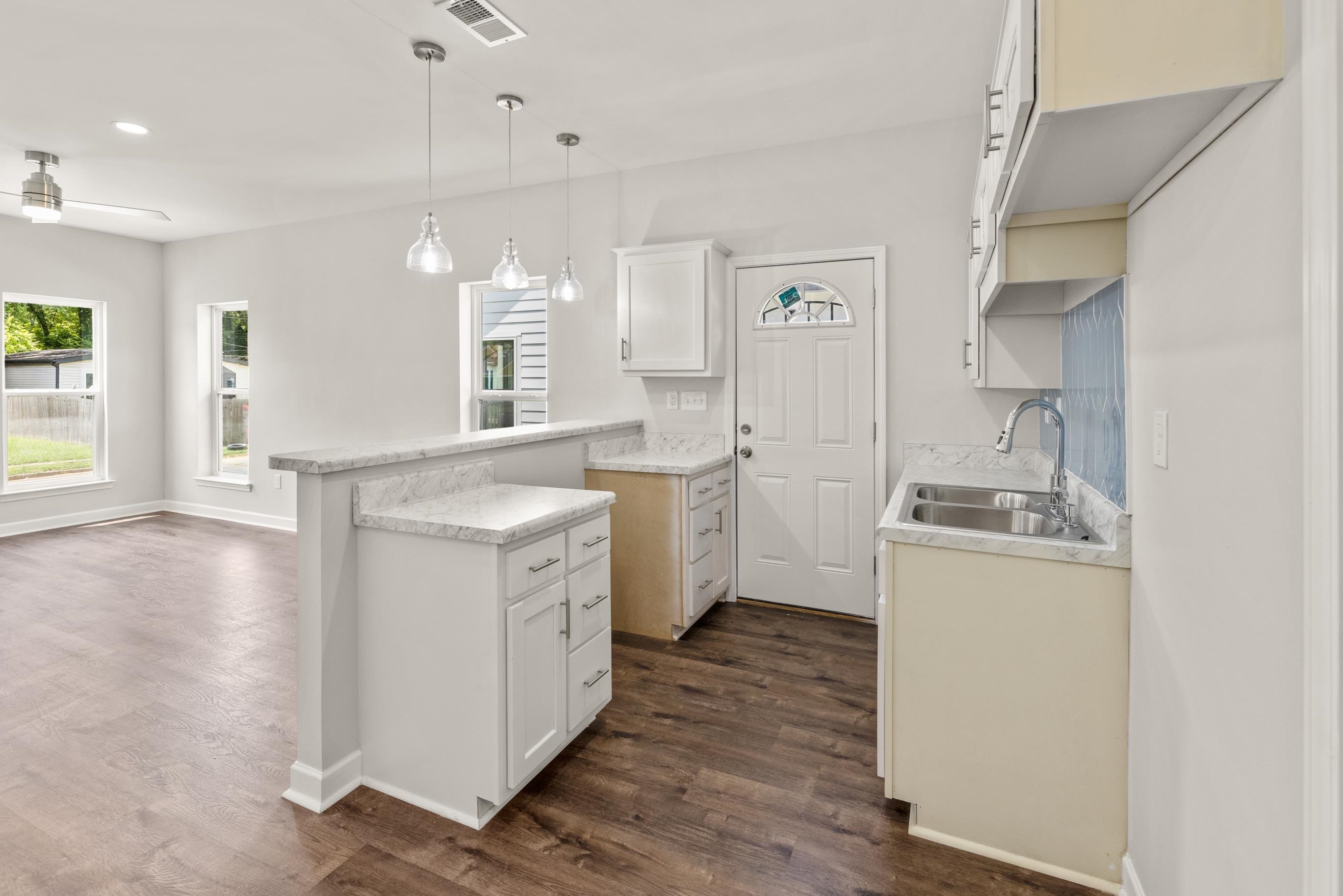 828 Semmes Street Memphis, TN 38111 - Photo 12 of 18 a kitchen with a sink stove and wooden floor