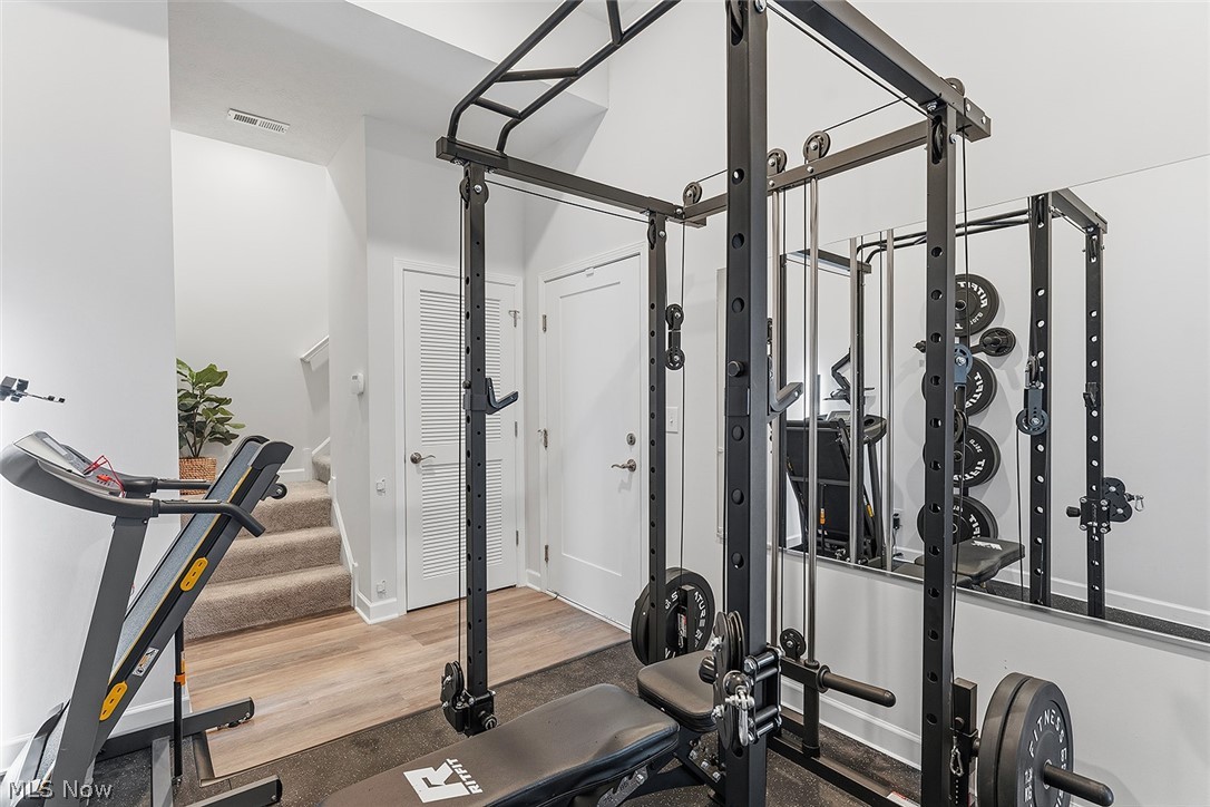 2308 Fulton Road Cleveland, OH 44113 - Photo 28 of 30 Dedicated fitness area featuring a wall-mounted mirror, light wood-finish flooring, and two white louvered doors