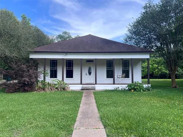 a front view of a house with a garden and yard