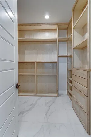 a view of walk in closet with empty racks