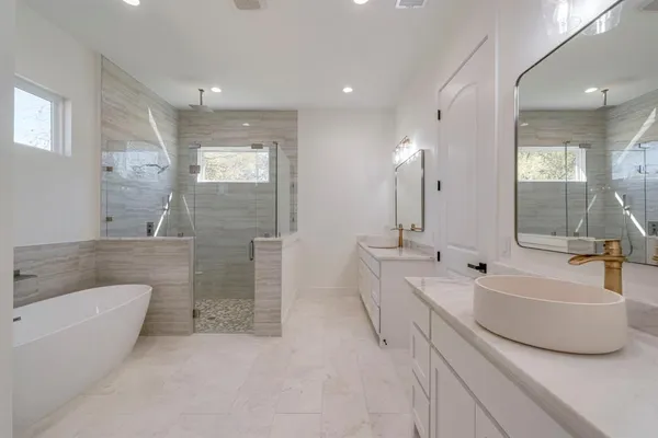 a spacious bathroom with a tub a double vanity sink and mirror