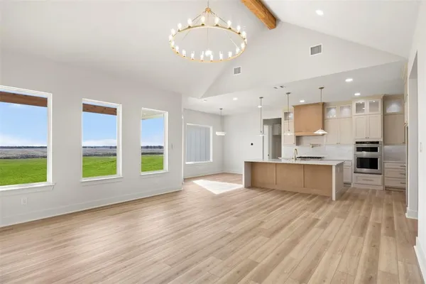 a large kitchen with stainless steel appliances kitchen island a large counter space and a window