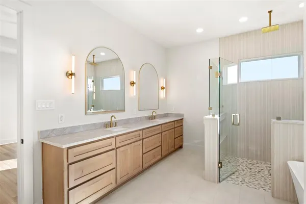 a bathroom with a double vanity sink and mirror with shower