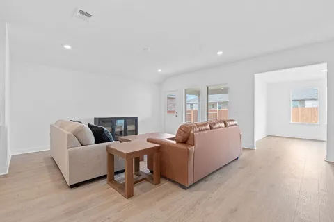 a living room with furniture and a wooden floor