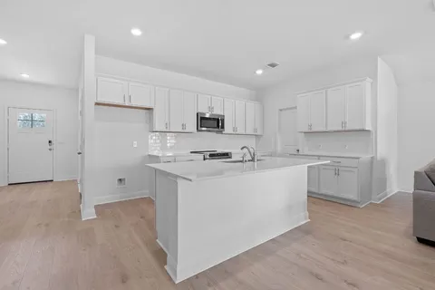 a kitchen with white cabinets and stainless steel appliances