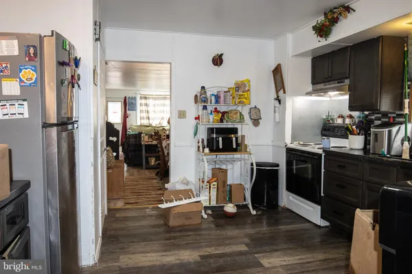 a living room with stainless steel appliances furniture and a flat screen tv