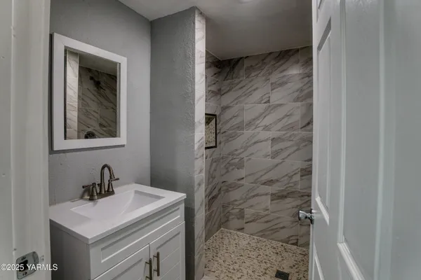 a bathroom with a sink a mirror and shower